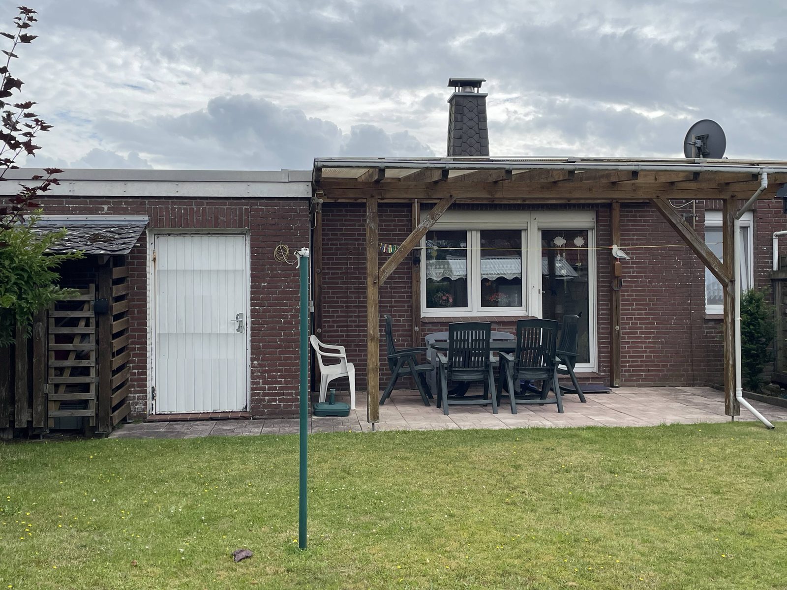 Rückansicht des Ferienhauses mit überdachter Terrasse und Sitzgruppe